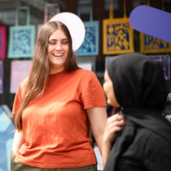 Three women chat and smile together.